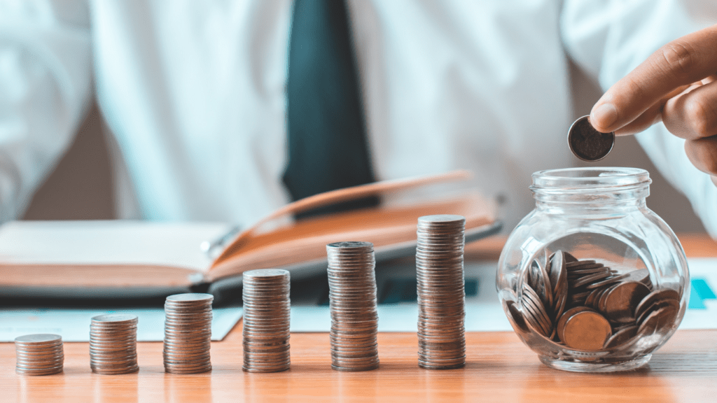 A person putting coins in a jar