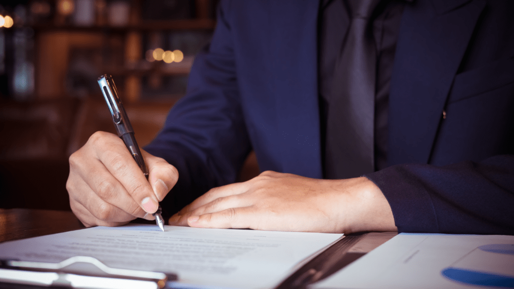 a person in a suit writing on a piece of paper