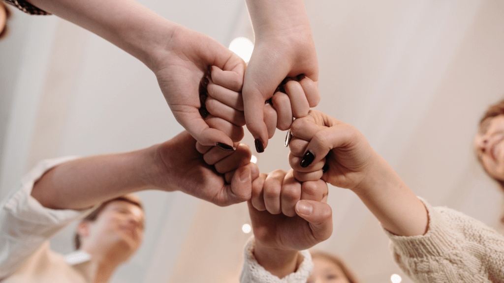 a group of people holding hands together in a circle