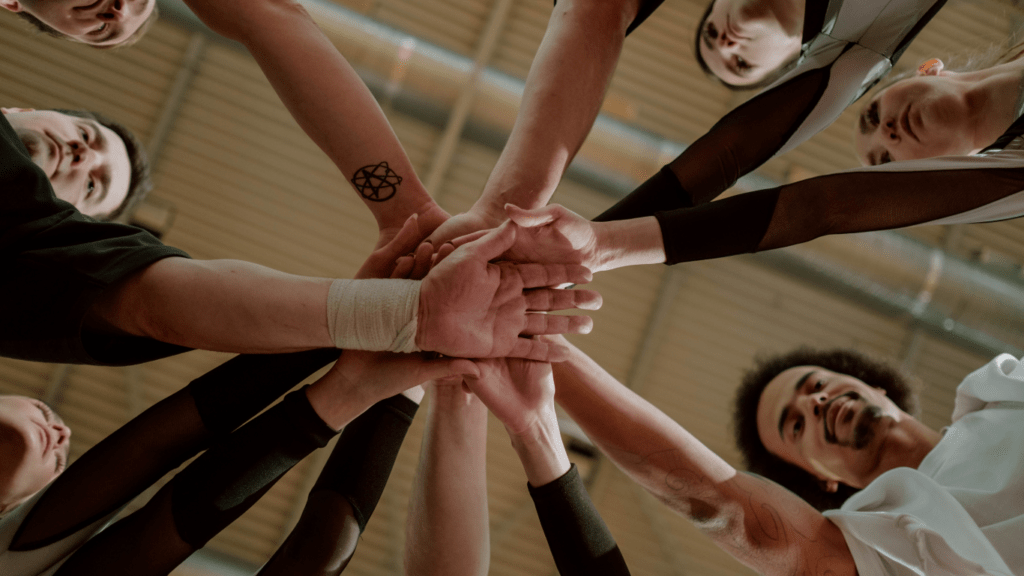 a group of people holding hands together in a circle