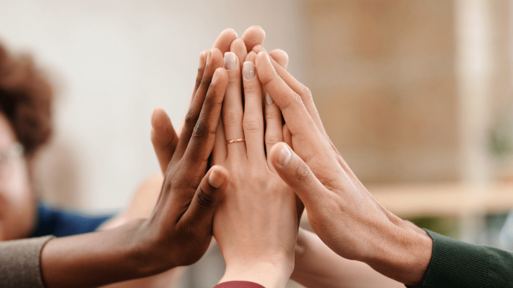 a group of people making a high five with their hands